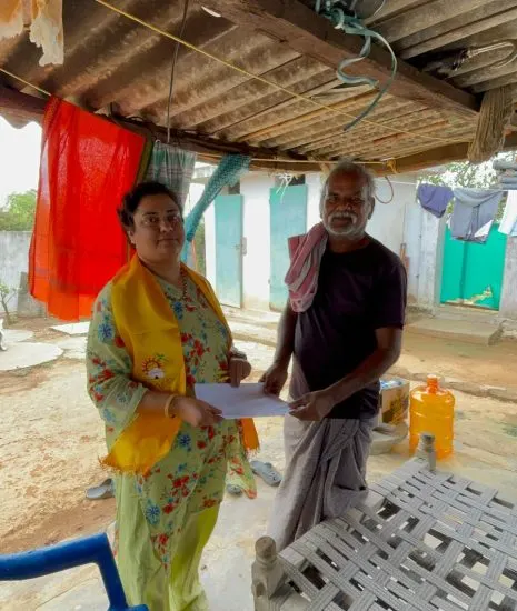 Krishna Priya receiving a written grievance from a resident outside his home during a door-to-door round.