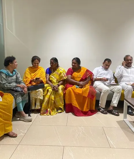 Women's wing representatives and party leaders waiting together ahead of a review meeting.